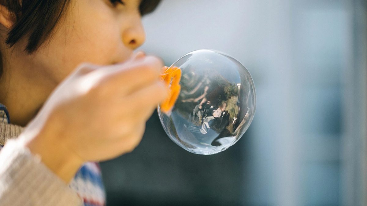 Young child blows bubbles