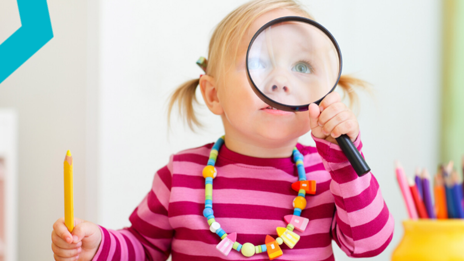 Toddler girl looking through magnifying glass